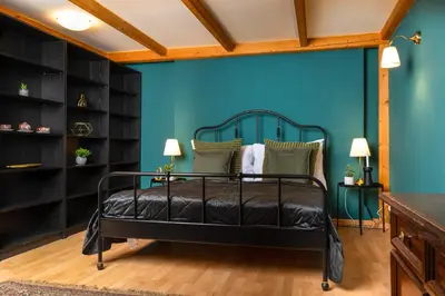 a bedroom with a black bed with a blue wall at Chateau Charme - Prague centre in Prague