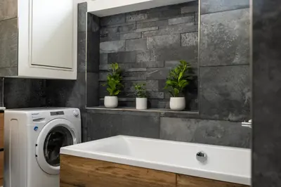 a white washing machine in a bathroom with plants at Chateau Charme - Prague centre in Prague