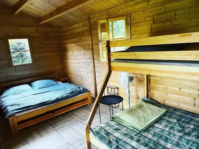 a bedroom with two bunk beds in a wooden cabin at Chatka Jägerhaus K myslivně 26 in Libochovice
