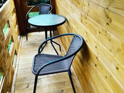 two chairs and a table on a wooden deck at Chatka Jägerhaus K myslivně 26 in Libochovice