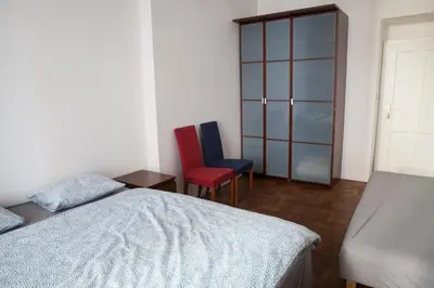 a bedroom with a bed and two chairs at 2B Pechackova family apartment with balcony by the river in Prague