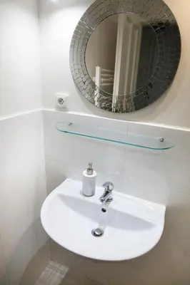 a bathroom with a white sink and a mirror at 2B Pechackova family apartment with balcony by the river in Prague