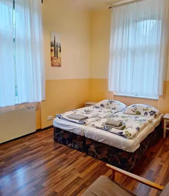a bedroom with a bed in a room with wooden floors at Apartmán Nad hradem in Týnec nad Sázavou