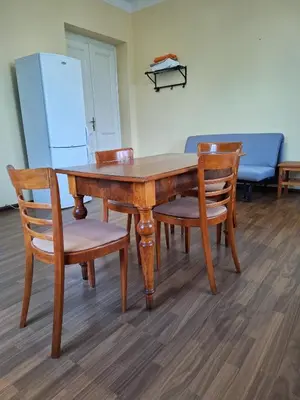 a wooden table with four chairs and a refrigerator at Apartmán Nad hradem in Týnec nad Sázavou