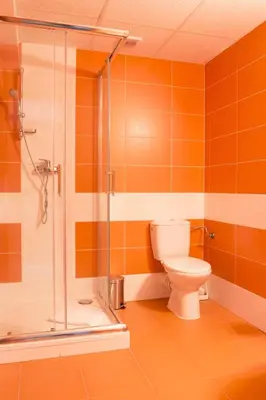 a bathroom with a toilet and a glass shower at Sporthotel Hostivice in Hostivice