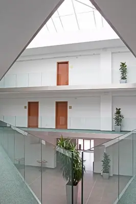an office building with glass walls and potted plants at Sporthotel Hostivice in Hostivice