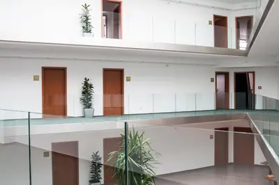 a glass staircase in a building with potted plants at Sporthotel Hostivice in Hostivice