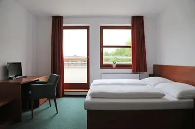 a bedroom with a bed and a desk and a computer at Sporthotel Hostivice in Hostivice