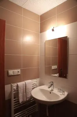 a bathroom with a sink and a mirror and towels at Sporthotel Hostivice in Hostivice