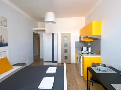a kitchen with yellow cabinets and a black table at ELSO apartments in Prague
