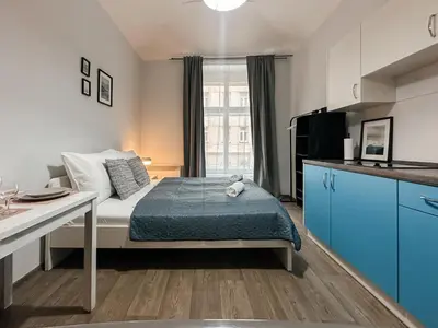 a small bedroom with a bed and a kitchen at ELSO apartments in Prague