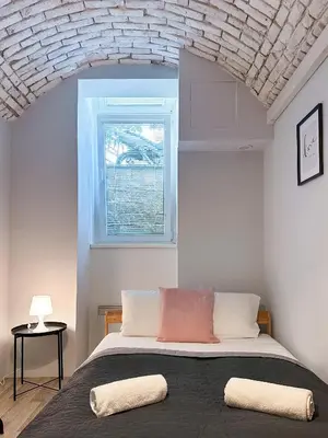 a bedroom with a large bed with a window at ELSO apartments in Prague