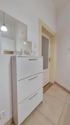 a kitchen with white cabinets and a white floor at Finnem Rentals Kyjevská in Prague