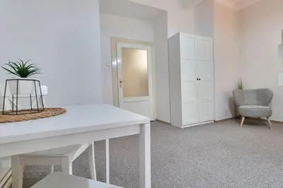 a white room with a table and a chair at Finnem Rentals Kyjevská in Prague