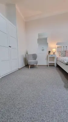 a room with a bedroom with a bed and a chair at Finnem Rentals Kyjevská in Prague