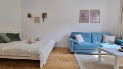 a living room with a blue couch and a table at Finnem Rentals Průběžná in Prague