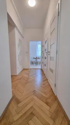an empty hallway with wooden floors and white walls at Finnem Rentals Průběžná in Prague