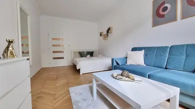 a living room with a blue couch and a table at Finnem Rentals Průběžná in Prague