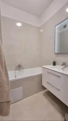 a white bathroom with a tub and a sink at Finnem Rentals Průběžná in Prague