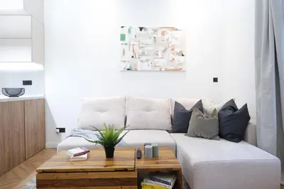 a living room with a white couch and a wooden coffee table at Rentero Cozy Apartment in picturesque Prague district in Prague