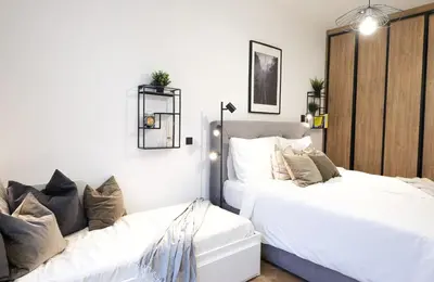 two beds in a bedroom with white walls at Rentero Cozy Apartment in picturesque Prague district in Prague