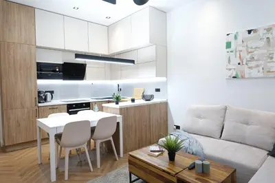 a kitchen and living room with a table and a couch at Rentero Cozy Apartment in picturesque Prague district in Prague