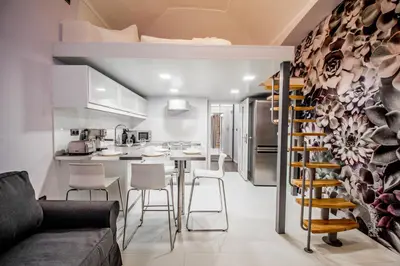 a kitchen and living room with a table and chairs at Ruterra Apartment Cimburkova in Prague
