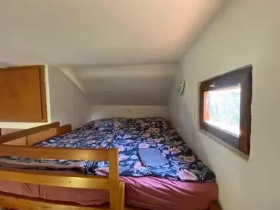 a small bedroom with a bed and a window at Apartmánová chata Martina in Hradištko