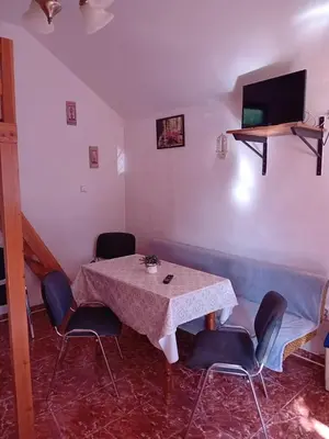 a dining room with a table and chairs and a tv at Apartmánová chata Martina in Hradištko