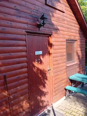a door to a log cabin with a picnic table at Apartmánová chata Martina in Hradištko