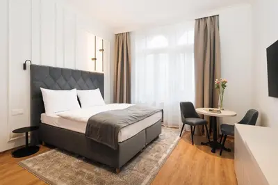 a bedroom with a bed and a table and chairs at NOBILIS RESIDENCE in Prague