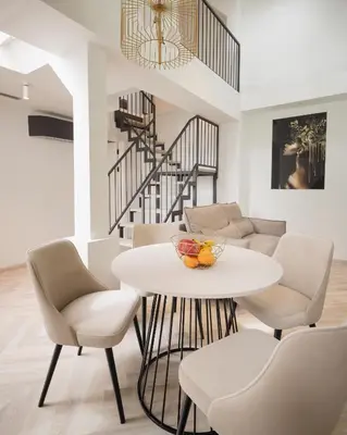 a living room with a table and chairs and a staircase at NOBILIS RESIDENCE in Prague