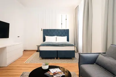 a bedroom with a bed and a living room with a couch at NOBILIS RESIDENCE in Prague