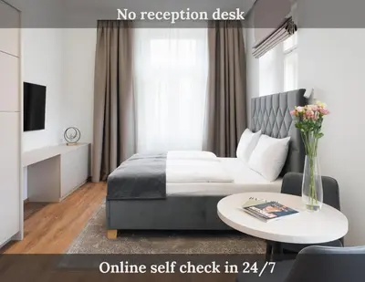 a bedroom with a bed and a table with a vase of flowers at NOBILIS RESIDENCE in Prague