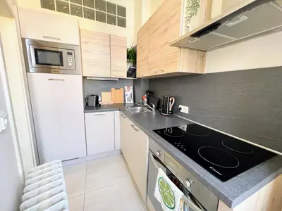 a small kitchen with a stove and a microwave at Beautiful & peaceful apartment with cute balcony in Prague