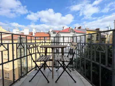 a table and chairs on a balcony with buildings at Beautiful & peaceful apartment with cute balcony in Prague