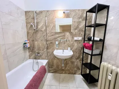 a bathroom with a white tub and a sink at Beautiful & peaceful apartment with cute balcony in Prague
