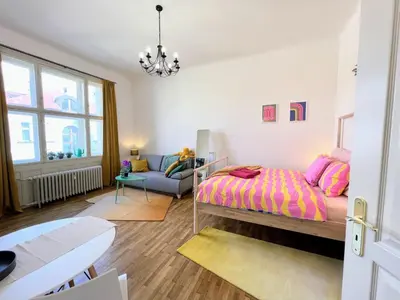 a bedroom with a bed and a couch at Beautiful & peaceful apartment with cute balcony in Prague