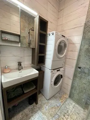 a bathroom with a washing machine and a sink at Vantisch Studio in Prague