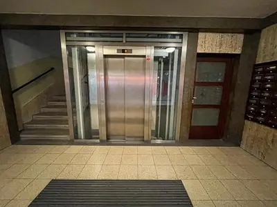 an elevator in a building with stairs and a door at Vantisch Studio in Prague