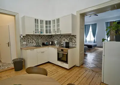 a kitchen with white cabinets and a table in a room at TRUHLÁŘSKÁ 4 APARTMENT in Prague