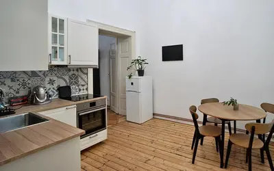 a kitchen with a table and a white refrigerator at TRUHLÁŘSKÁ 4 APARTMENT in Prague