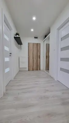 a hallway with white walls and wooden doors at Finnem Rentals Varnsdorfská in Prague
