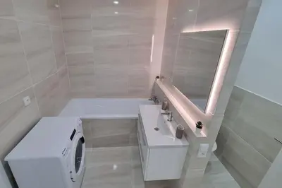 a bathroom with a sink and a washing machine at Finnem Rentals Varnsdorfská in Prague