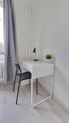 a white desk with a chair and a lamp at Finnem Rentals Varnsdorfská in Prague