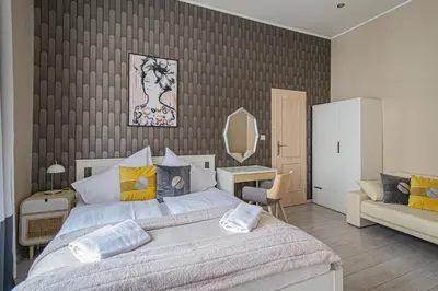 a bedroom with a bed and a couch and a mirror at Ruterra Apartment Charles Bridge in Prague