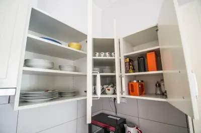 a kitchen with white cabinets with plates and utensils at Ruterra Apartment Charles Bridge in Prague