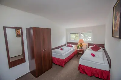 a hotel room with two beds and a mirror at Hotel Koliba in Litoměřice