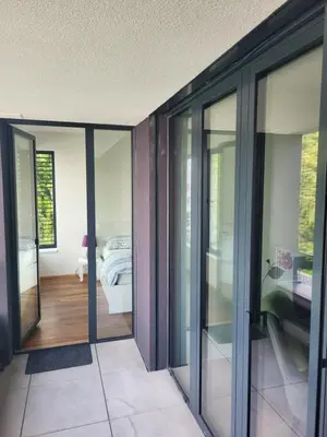 a room with sliding glass doors and a bedroom at New apartment in Karlín, Praha 8, close to center in Prague