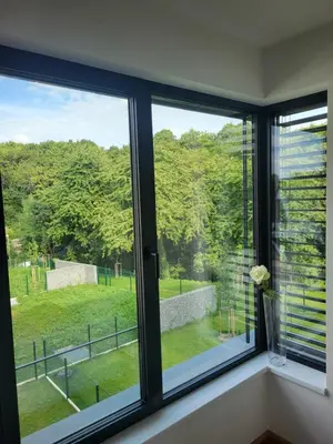 a window with a view of a green field at New apartment in Karlín, Praha 8, close to center in Prague